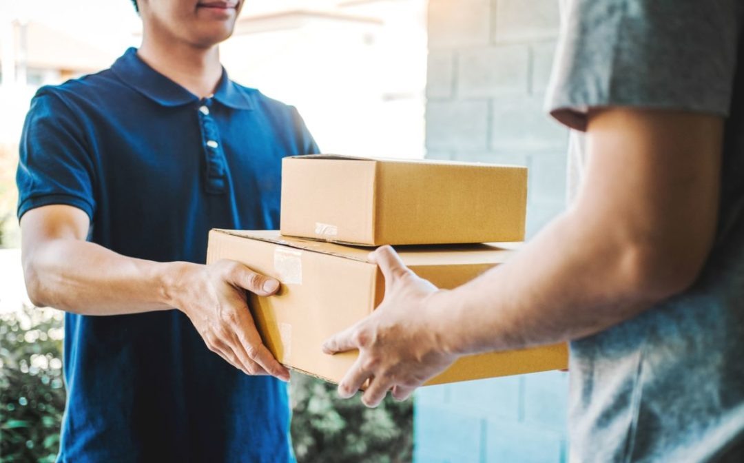 Delivery of oversized items with person using hand truck.