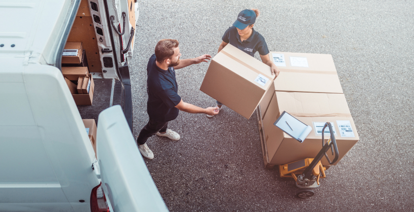 Two people loading van with large items for delivery.